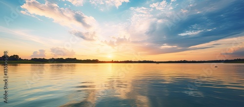 Fototapeta Naklejka Na Ścianę i Meble -  yellow sunset where the river flows into the sea there are low blue clouds in the sky. Creative banner. Copyspace image