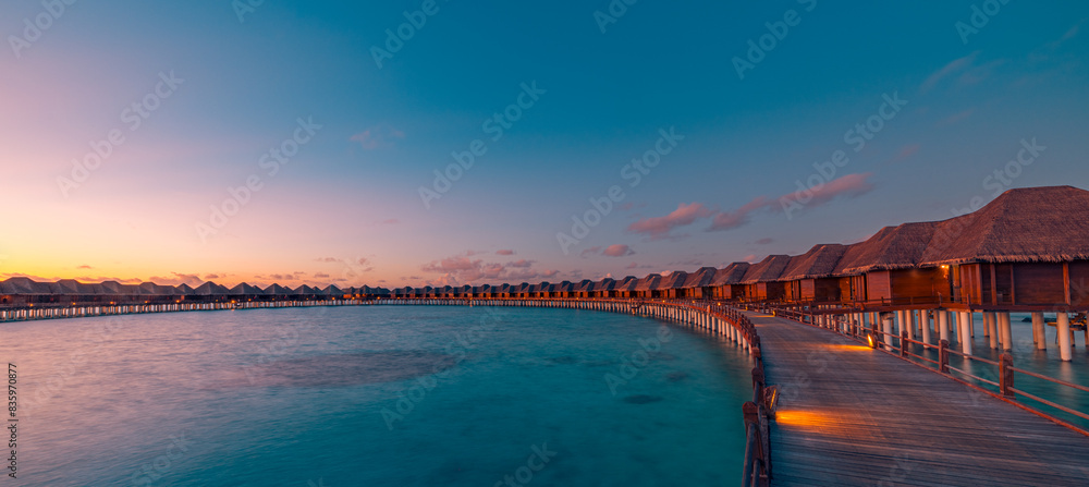 Summer travel landscape seascape. Amazing sunset panorama Maldives. Luxury resort villas seascape, soft led lights under colorful dreamy sea sky reflection. Sunrays majestic sunlight, perfect vacation