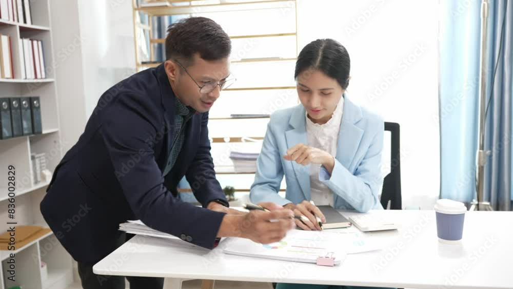 Asian business man and woman are busy working with documents, financial graphs and consulting laptops. Smart planning Colleagues discuss work problems Give advice while sitting in the office Asian business man and woman are busy working with documents, financial graphs and consulting laptops. Smart planning Colleagues discuss work problems Give advice while sitting in the office