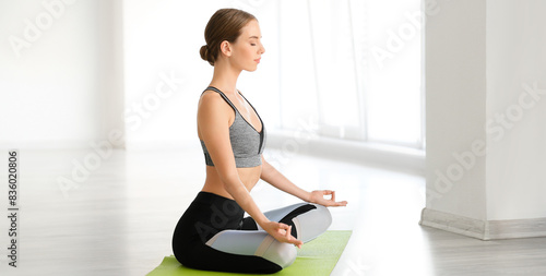 Young woman practicing yoga...