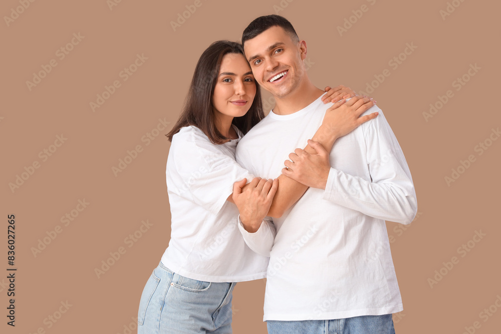 Stylish young couple hugging on brown background Stylish young couple hugging on brown background
