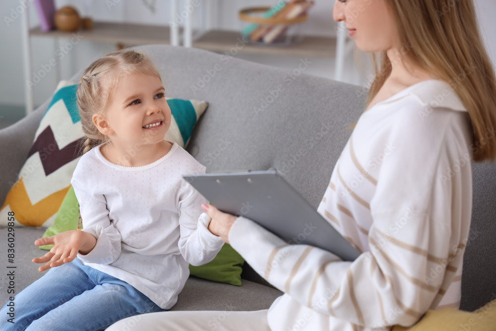 Little girl talking to psychologist on sofa in office Little girl talking to psychologist on sofa in office