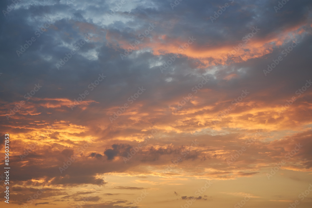 Obraz premium A fragment of a bright sunset sky with bizarrely shaped clouds