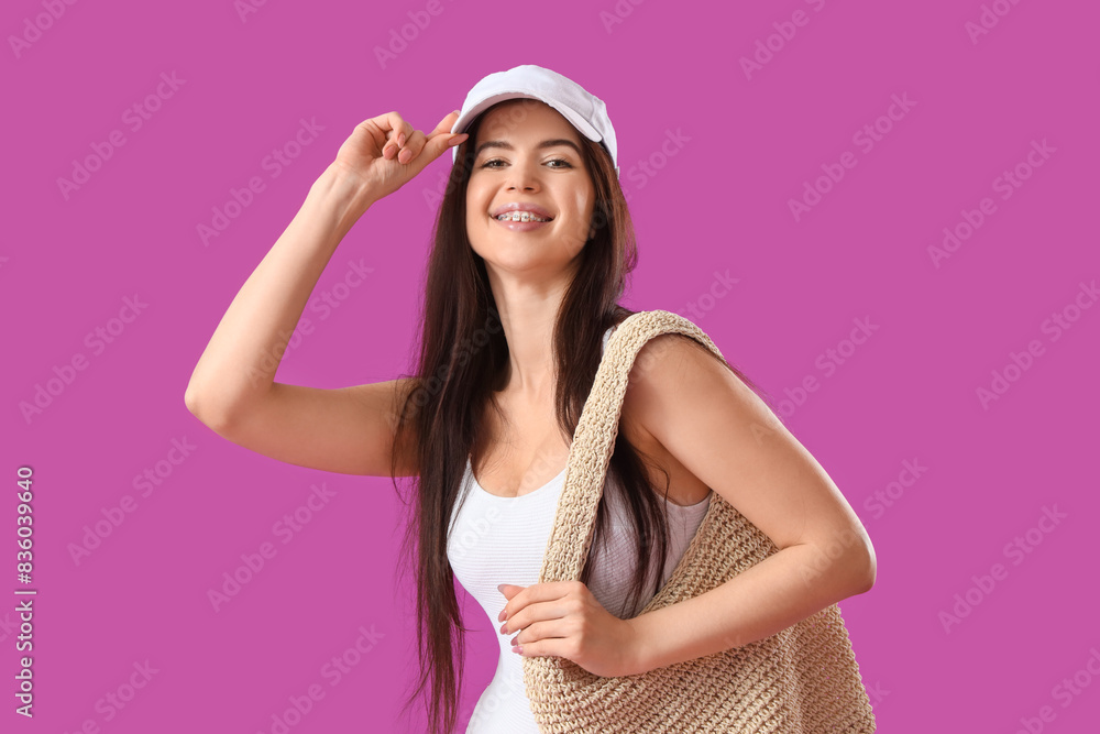 Portrait of pretty young woman in swimsuit with wicker handbag on pink background Portrait of pretty young woman in swimsuit with wicker handbag on pink background