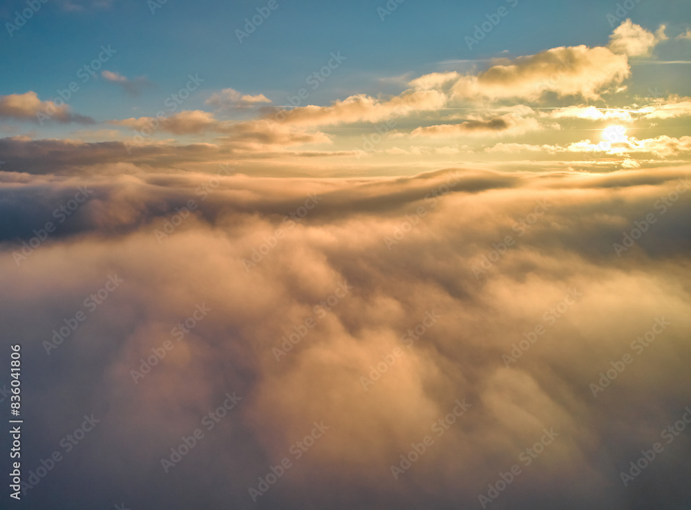 Fog spreads over the mountains at dawn. The sun rises on the horizon. Carpathians in the morning. Aerial drone view. Fog spreads over the mountains at dawn. The sun rises on the horizon. Carpathians in the morning. Aerial drone view.