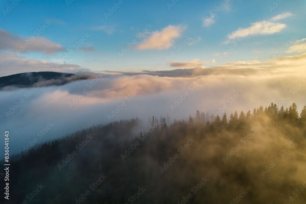 Fog spreads over the mountains at dawn. The sun rises on the horizon. Carpathians in the morning. Aerial drone view. Fog spreads over the mountains at dawn. The sun rises on the horizon. Carpathians in the morning. Aerial drone view.