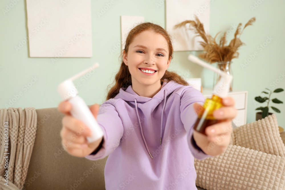 Happy young woman with medical sprays at home Happy young woman with medical sprays at home