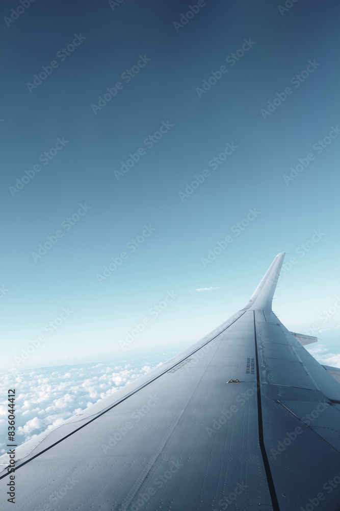 Airplane Wing View Over Clouds and Clear Sky Airplane Wing View Over Clouds and Clear Sky