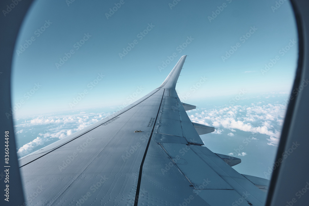 Airplane Wing View from Window with Blue Sky and Clouds Airplane Wing View from Window with Blue Sky and Clouds