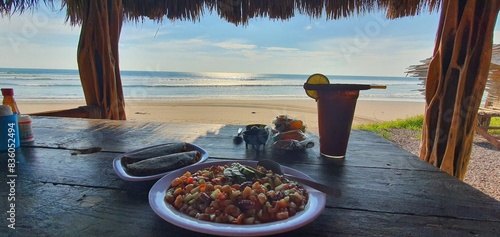 Tableau sur toile Idyllic Beachfront Dining: Enjoying a Delicious Seafood Meal with a Panoramic Oc