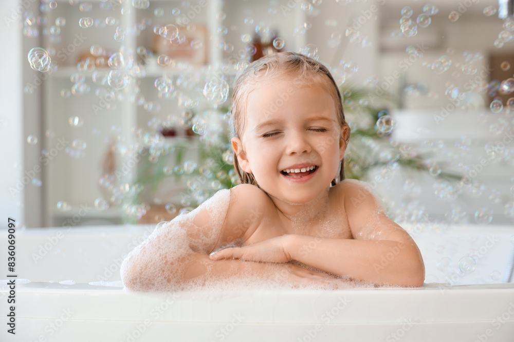Cute little girl with soap bubbles taking bath in bathroom Cute little girl with soap bubbles taking bath in bathroom