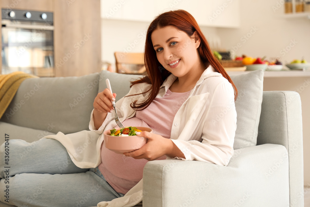 Young pregnant woman with fresh vegetable salad lying on sofa at home Young pregnant woman with fresh vegetable salad lying on sofa at home