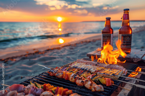 Skewers and bottles of beer on a beach barbecue at sunset. photo