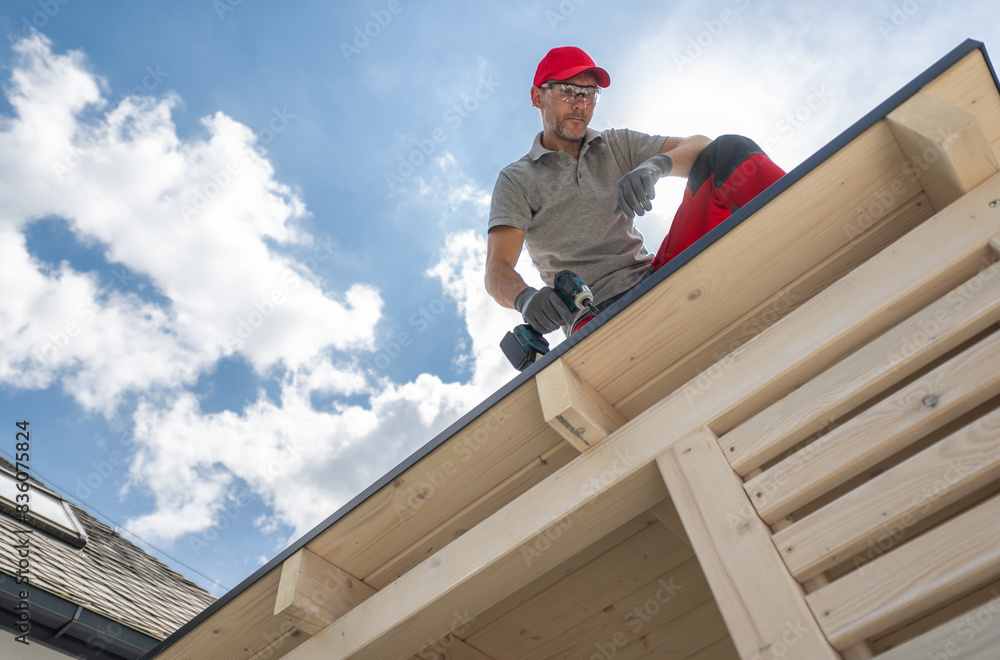 Construction Worker on Roof Using Drill Construction Worker on Roof Using Drill