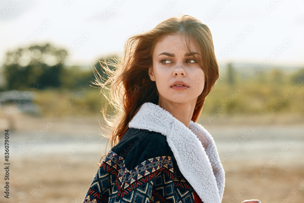 Serene woman standing in open field with trees in background on sunny day Serene woman standing in open field with trees in background on sunny day