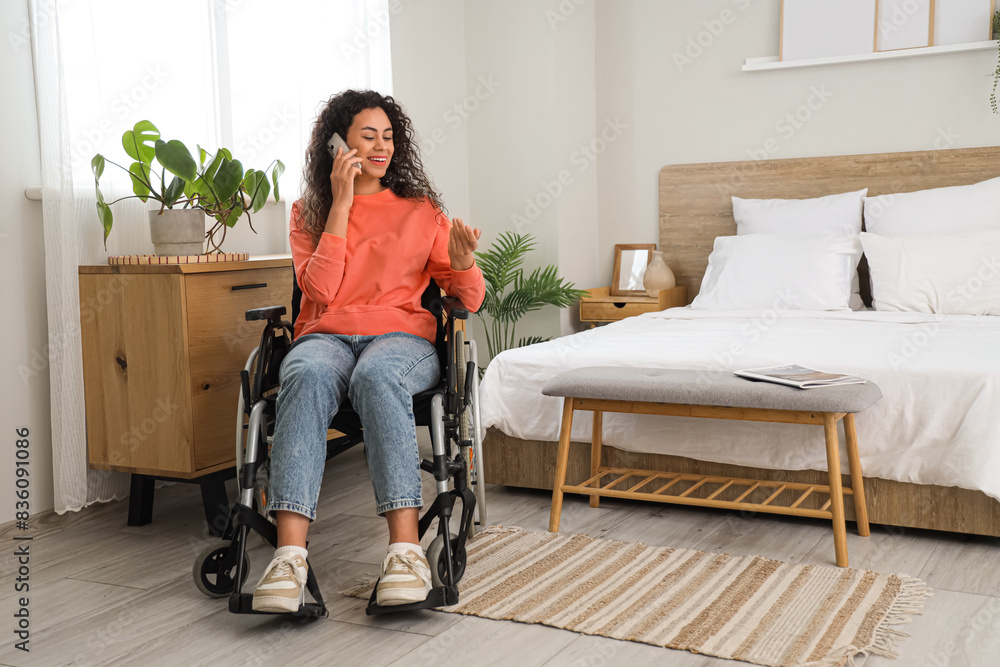 Young African-American woman in wheelchair talking by phone at home Young African-American woman in wheelchair talking by phone at home