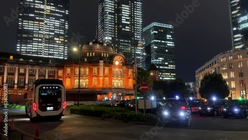 Fuel cell bus at night in a modern cityscape with illuminated skyscrapers and historic buildings