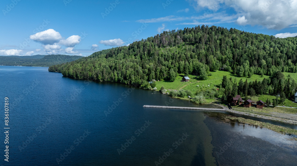 beautiful landscape with mountains and Lake Teletskoye against a background of blue sky from a drone in May