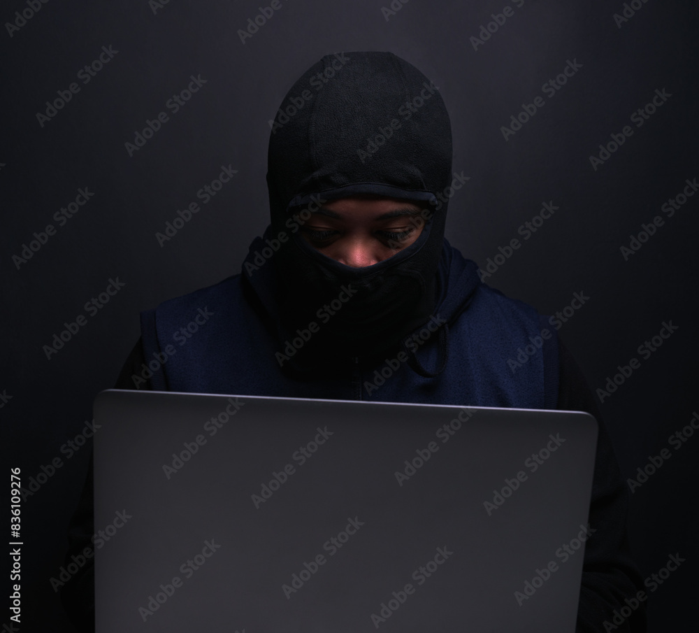 Cybersecurity, hacker and man with laptop in studio for information technology, crime and fraud. Network, risk and programming with cyber attack for database, firewall and malware on black background Cybersecurity, hacker and man with laptop in studio for information technology, crime and fraud. Network, risk and programming with cyber attack for database, firewall and malware on black background