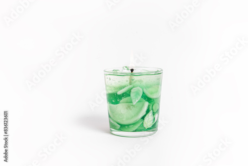 Trendy gel candle in the form of a mojito with ice on white background