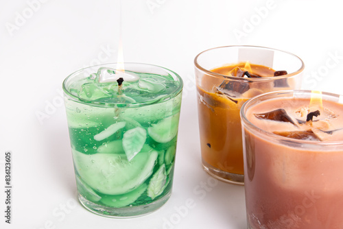 Trendy gel candles in glass cups on white background. Candles in the form of drinks. Mojito and iced coffee