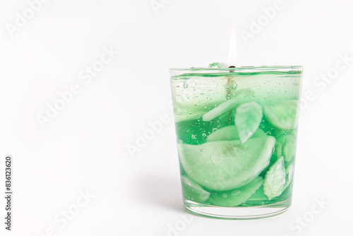 Trendy gel candle in the form of a mojito with ice on white background. Free space for text