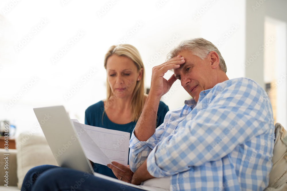 Couple, couch and document with laptop and stress, finances or taxes for debt in living room. Paperwork, planning or online for mortgage, upset people and budget for inflation or bankruptcy in home Couple, couch and document with laptop and stress, finances or taxes for debt in living room. Paperwork, planning or online for mortgage, upset people and budget for inflation or bankruptcy in home