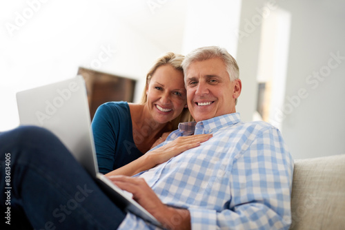 Couple, couch and laptop with portrait in home, streaming and relax in living room for movies. Internet, computer or website for video and mature married people, smile and lounge with technology © peopleimages.com