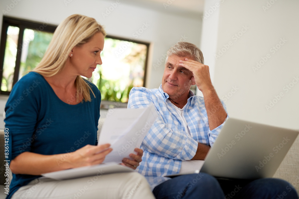Couple, couch and document with laptop and stress, finances or taxes for debt in lounge. Paperwork, mature or man and female person for mortgage, upset and budget for inflation or bankruptcy in home Couple, couch and document with laptop and stress, finances or taxes for debt in lounge. Paperwork, mature or man and female person for mortgage, upset and budget for inflation or bankruptcy in home