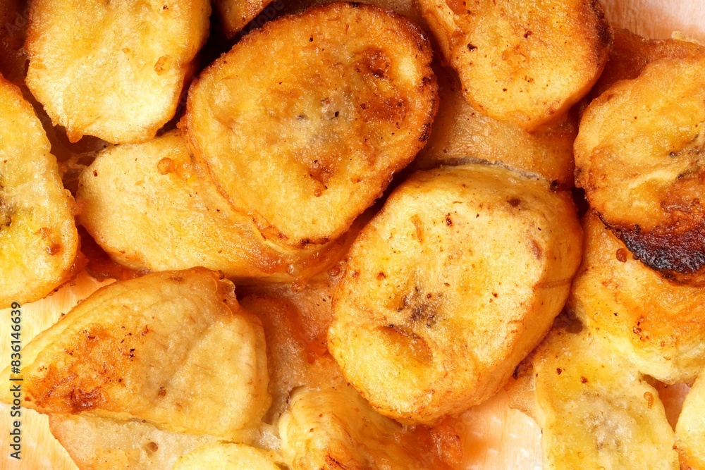 A close-up of crispy banana fritters, coated in golden batter and cut into bite-sized pieces. Perfect for capturing the delicious, mouthwatering appeal of this popular snack. A close-up of crispy banana fritters, coated in golden batter and cut into bite-sized pieces. Perfect for capturing the delicious, mouthwatering appeal of this popular snack.