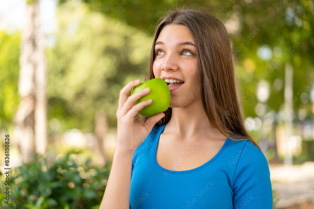 Teenager girl at outdoors holding an apple Teenager girl at outdoors holding an apple