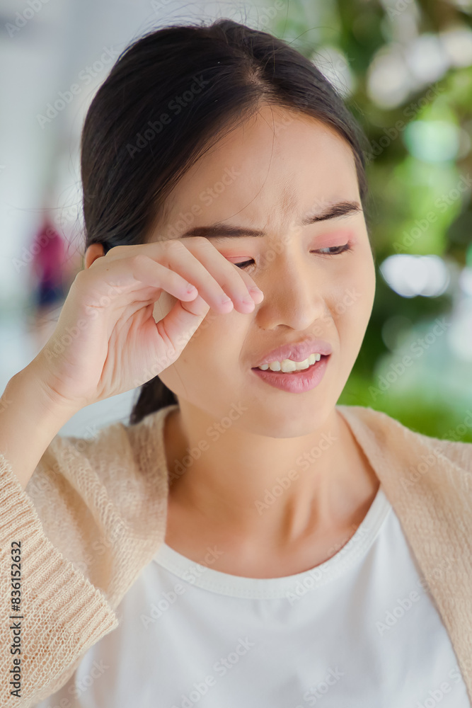 asian woman suffering from irritated eye; concept of optical health care, red eye allergy, eye care, allergic or itching or dry eye inflammation; young adult asian woman model asian woman suffering from irritated eye; concept of optical health care, red eye allergy, eye care, allergic or itching or dry eye inflammation; young adult asian woman model