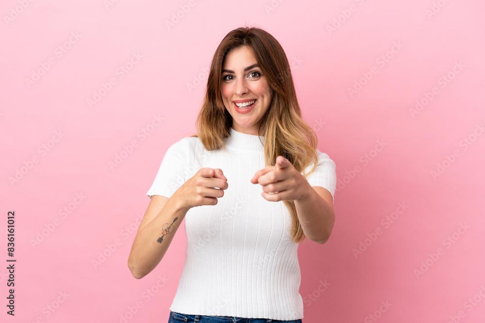 Caucasian woman isolated on pink background surprised and pointing front Caucasian woman isolated on pink background surprised and pointing front