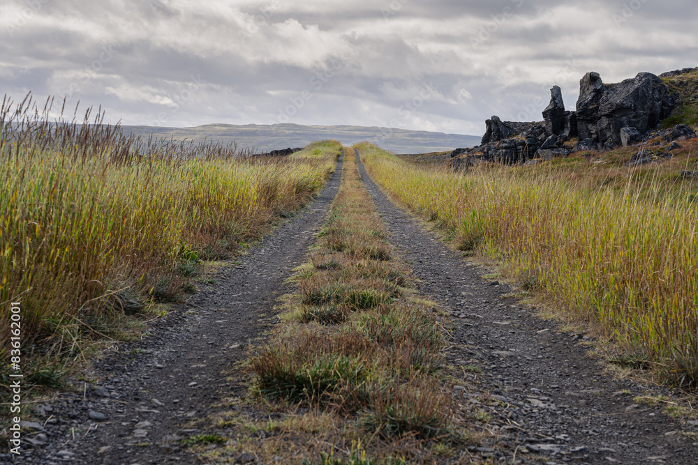 Fototapeta premium Endless gravel road leading up to clouds. The way forward concept