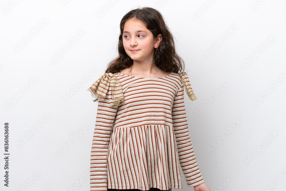 Little girl isolated on white background making doubts gesture looking side Little girl isolated on white background making doubts gesture looking side