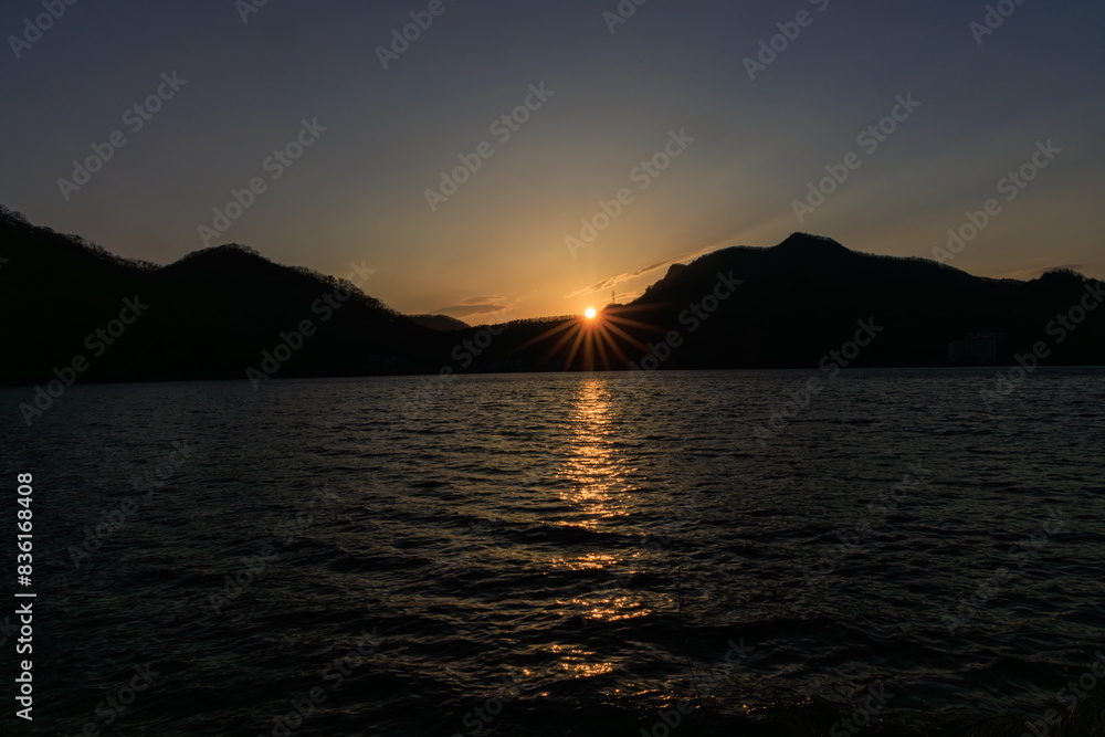早春の榛名湖の山に沈む美しい夕日