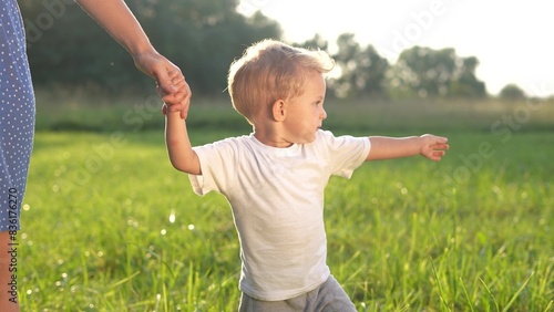 mother and baby a son walking in the park. happy family walking in the park in nature relaxing outdoors. happy family kid dream concept. lifestyle mother and child walking in the park