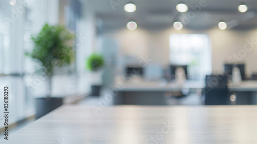 Blurred office background with empty desk. Modern, bright office setting out of focus with empty desk space in the foreground, perfect for product placement or background use.