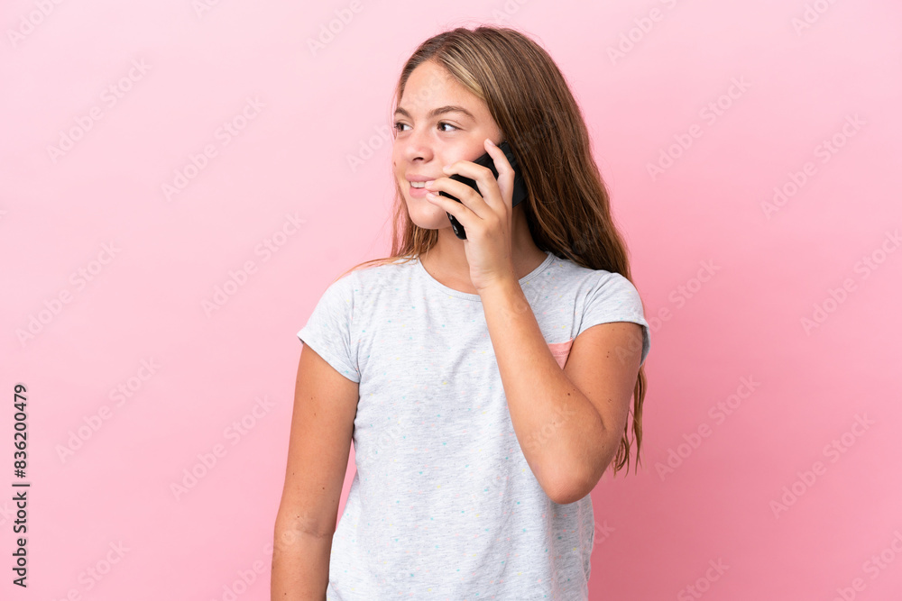 Little caucasian girl isolated on pink background keeping a conversation with the mobile phone with someone Little caucasian girl isolated on pink background keeping a conversation with the mobile phone with someone