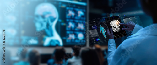 Obraz na płótnie A group of medical professionals reviewing and analyzing detailed brain scans displayed on digital screens and tablets, highlighting advanced AI medical imaging technology. w salonie