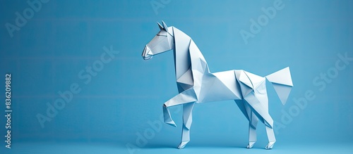 Blue origami horse symbol on white backdrop with copy space image. photo