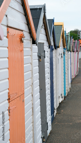 Close up of traditional English seaside beach huts with bright coloured doors at popular holiday destination in Devon, England UK