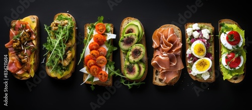 Top view of sandwiches or assorted canapes on a dark background with copy space image.