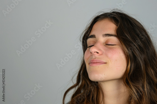 A close up of a woman's face with her eyes closed looking to a side © MagnusCort