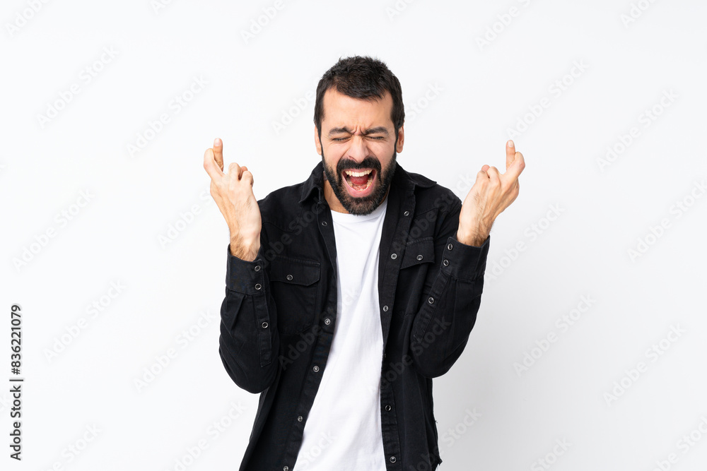 Young man with beard over isolated white background with fingers crossing Young man with beard over isolated white background with fingers crossing
