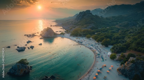 Aerial view of La Marinedda wild beach in Sardinia at sunset, showcasing turquoise waters, rocky shores, and a beach crowded with visitors. photo