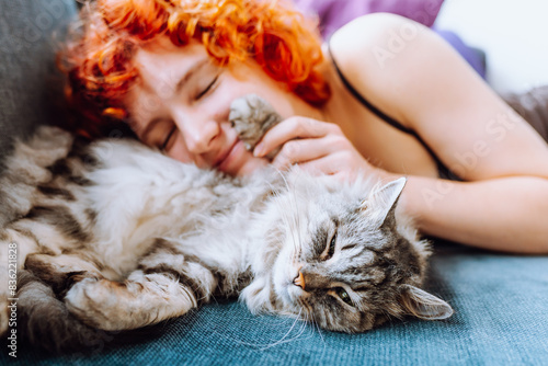 portrait red-haired teenage girl with gray fluffy cat photo