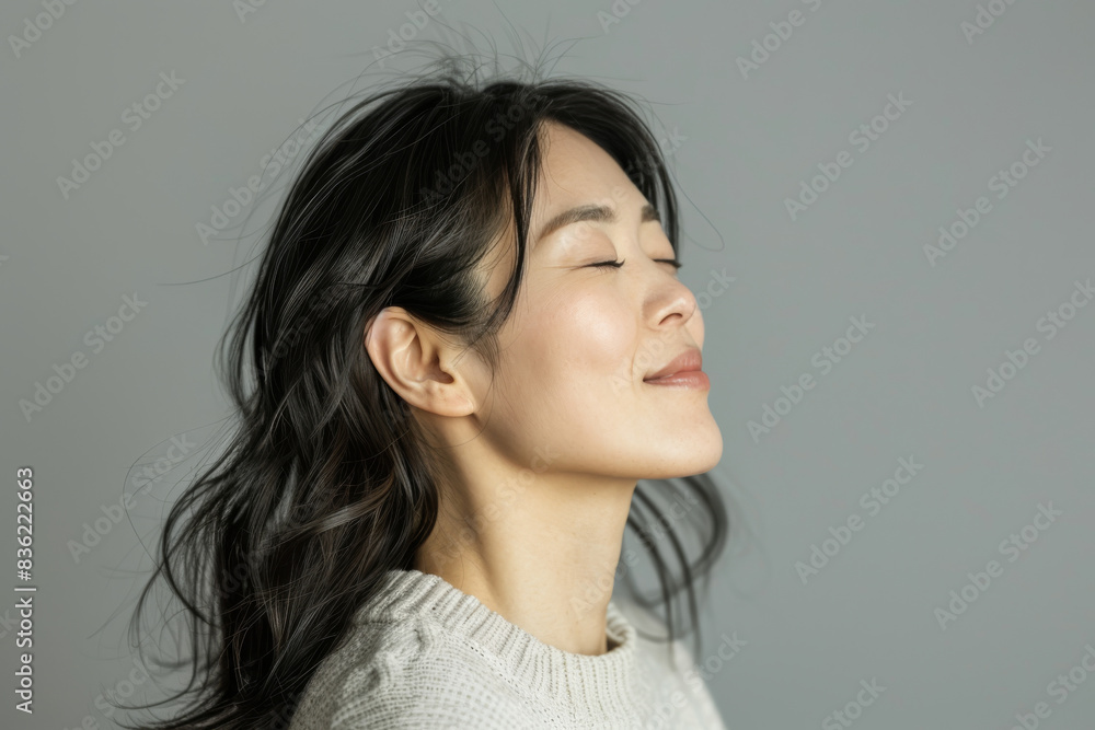 A close up of a woman's face with her eyes closed looking to a side A close up of a woman's face with her eyes closed looking to a side