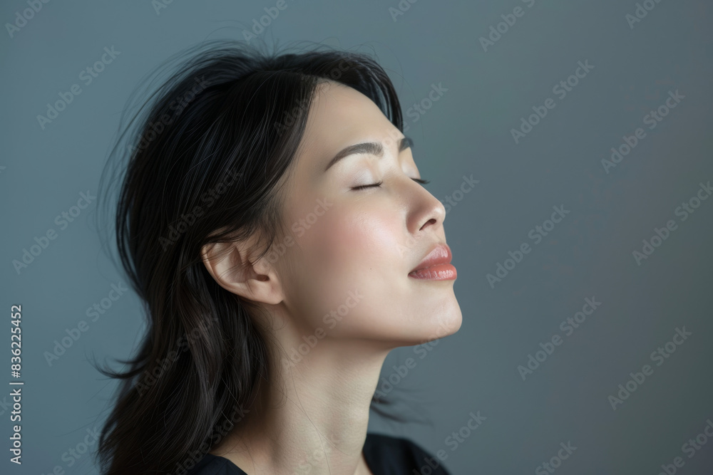 A close up of a woman's face with her eyes closed looking to a side A close up of a woman's face with her eyes closed looking to a side