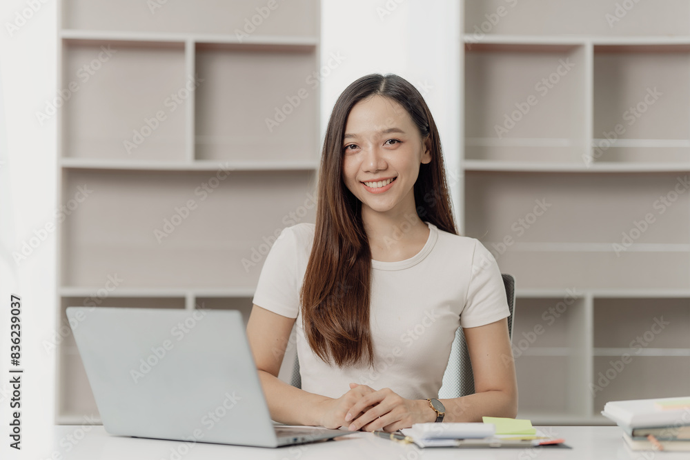 Businesswoman working on financial documents on the desk in the office is writing notes and calculating income and expenses. Businesswoman working on financial documents on the desk in the office is writing notes and calculating income and expenses.